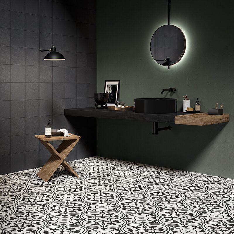 D'amico Ceramique Reveri floral patterned ceramic tiles in black and white in bathroom with dark grey tile walls and black and wooden accessories and details